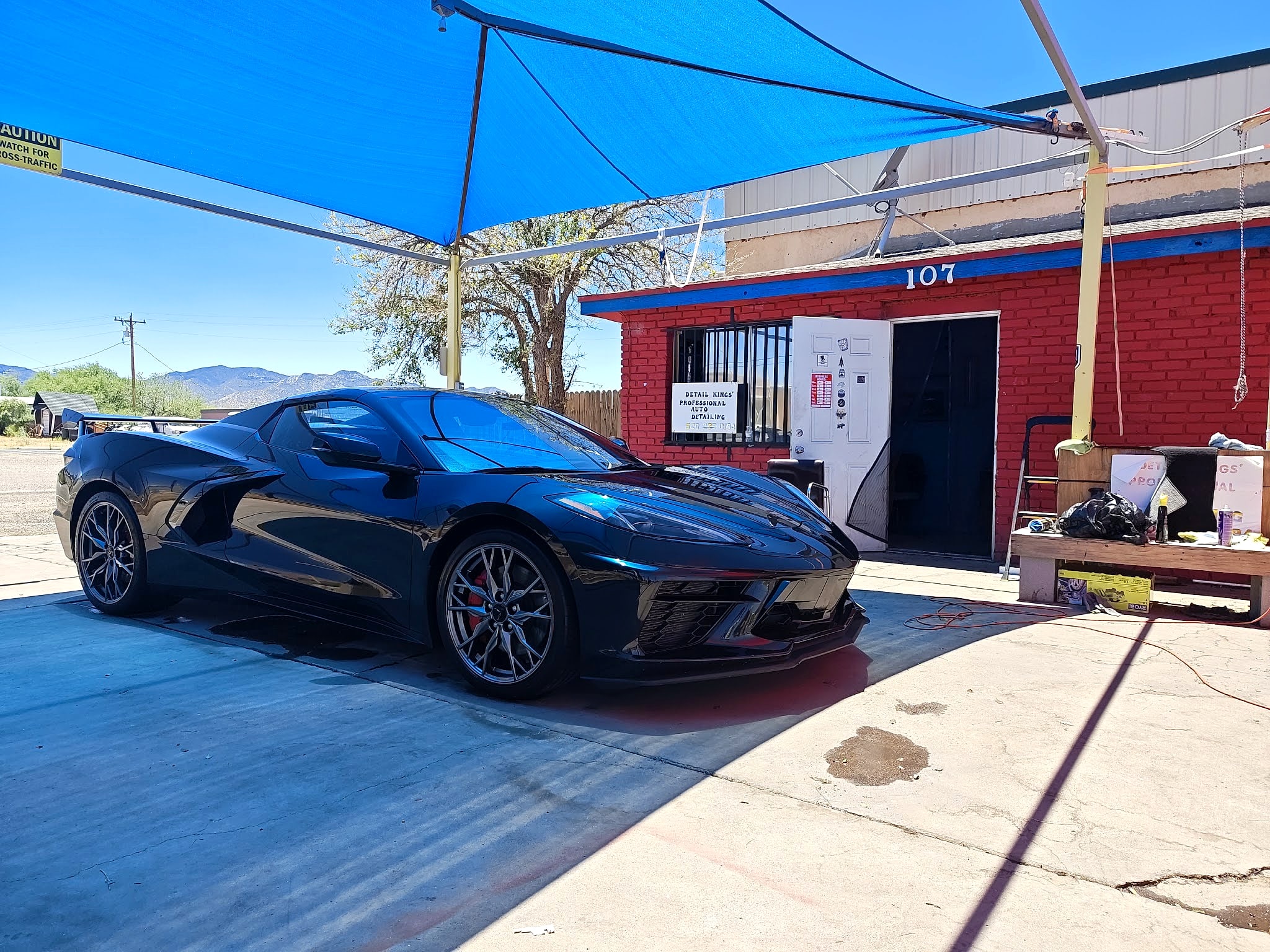 Black mid-engine Corvette in front of the Desert Rain building