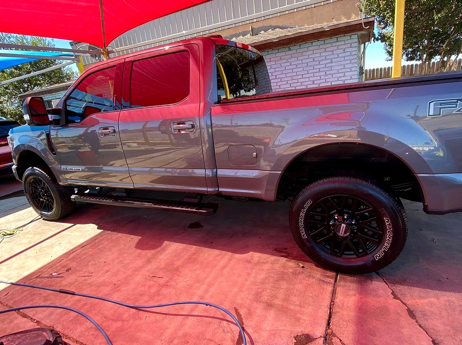Grey Ford pickup under the red canopy