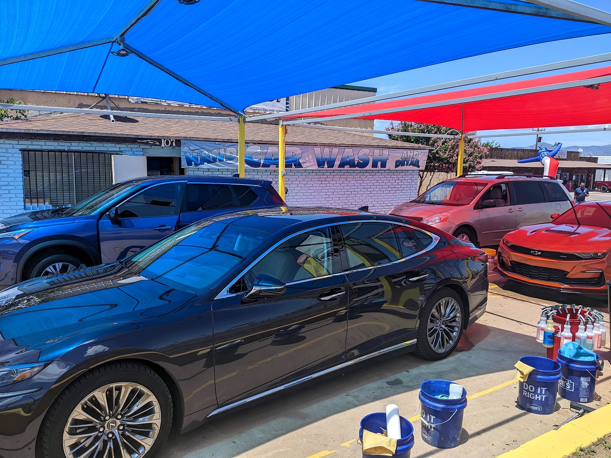 Cars lined up under the blue shade canopy at the wash